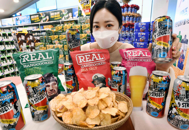 모델이 27일 서울 등촌동 홈플러스 강서점에서 ‘9스트리트(9Streets)’ 발포주와 리얼 감자칩을 선보이고 있다. (제공: 홈플러스)