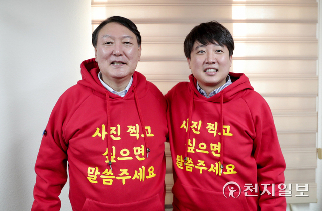 [천지일보=박준성 기자] 국민의힘 윤석열 대선후보와 이준석 대표가 4일 부산 수영구 국민의힘 부산시당에서 열린 선거대책회의에서 ‘사진 찍고 싶으면 말씀주세요’ 문구가 적힌 빨간색 후드티를 선보이고 있다. (제공: 윤석열 캠프) ⓒ천지일보 2021.12.4