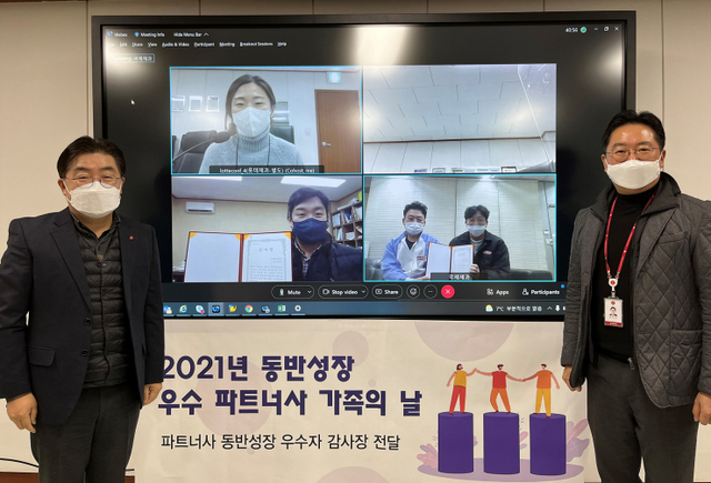 롯데제과 박경섭 생산본부장(왼쪽)과 김대균 생산전략부문장이 화상회의로 진행된 ‘동반성장 우수 파트너사 가족의 날’ 행사에서 기념촬영을 하고 있다. (제공: 롯데제과)