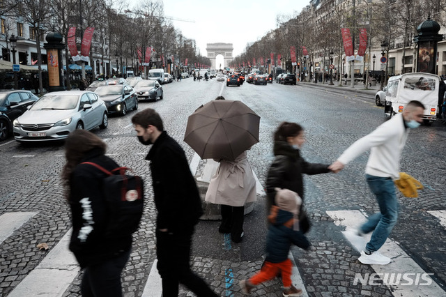 [파리=AP/뉴시스] 28일(현지시간) 프랑스 파리의 샹젤리제 거리에서 마스크를 쓴 시민들이 건널목을 건너고 있다.