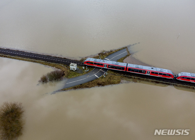2월 3일 독일에 기록적인 폭우가 쏟아진 가운데 프랑크푸르트 인근 니데라우에서 한 기차가 범람한 철길 건널목을 지나고 있다. (출처: 뉴시스)