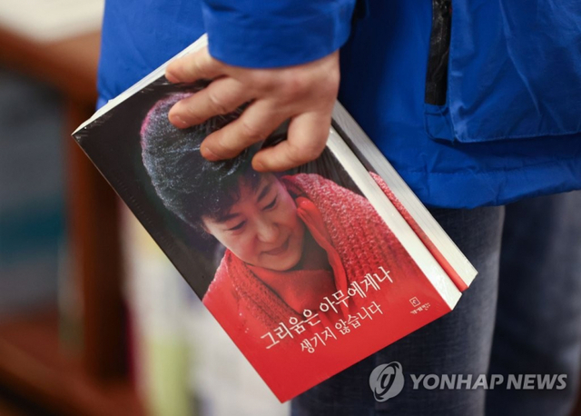 30일 오후 서울 시내 한 대형 서점에서 한 시민이 박근혜 전 대통령의 자서전 '그리움은 아무에게나 생기지 않습니다'를 구매하고 있다. (출처: 연합뉴스)
