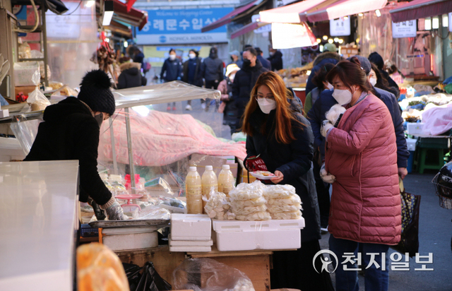 [천지일보=안채린 수습기자] 2021년 마지막 날인 31일 서울 중구 남대문시장에서 사람들이 떡을 구입하고 있다. ⓒ천지일보 2021.12.31