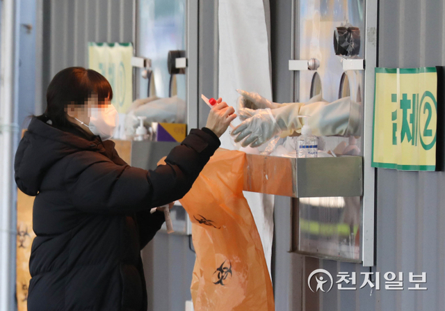 [천지일보=남승우 기자] 신종 코로나바이러스 감염증(코로나19) 신규 확진자가 3833명으로 집계된 2일 오후 서울 중구 서울광장 임시 선별검사소에서 한 시민이 코로나19 검체 키트를 의료진에게 전달하고 있다. ⓒ천지일보 2022.1.2