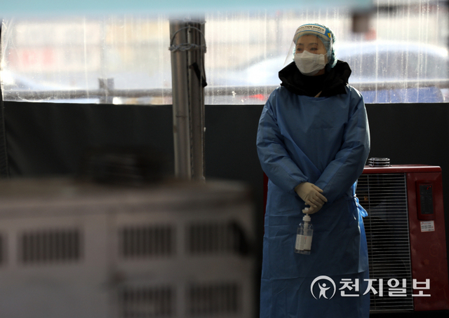 [천지일보=남승우 기자] 신종 코로나바이러스 감염증(코로나19) 신규 확진자가 4444명으로 집계된 5일 오전 서울역 광장 임시 선별검사소에서 검사 안내를 위해 서 있던 의료진이 난로 앞에서 몸을 녹이고 있다. ⓒ천지일보 2022.1.5