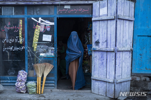 부르카를 착용한 한 여성이 5일(현지시간) 아프가니스탄 카불의 작은 가게에서  나오고 있다. 카불의 여성 인권 운동가들은 교육, 고용, 정치 및 사회 참여에 대한 권리를 위해 투쟁을 계속할 것이라며 최근 강제 결혼을 금지한 탈레반 법령은 여성 인권 문제를 다루기에 충분하지 않다고 주장했다. 2021.12.06. (출처: AP/뉴시스)