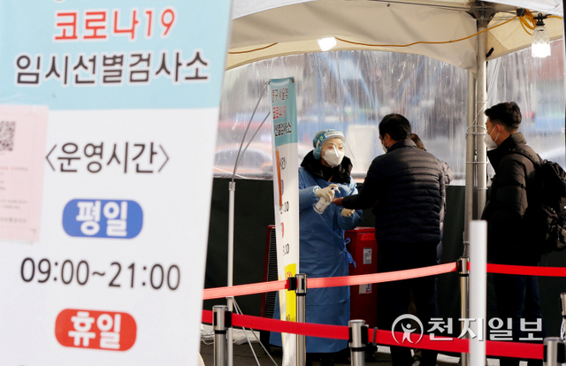 [천지일보=오주영 수습기자] 5일 서울 중구 서울역 광장에 위치한 코로나19 임시선별검사소의 한 의료진이 코로나19 검사를 받으려는 한 시민에게 손소독제를 제공하고 있다. ⓒ천지일보 2022.1.5