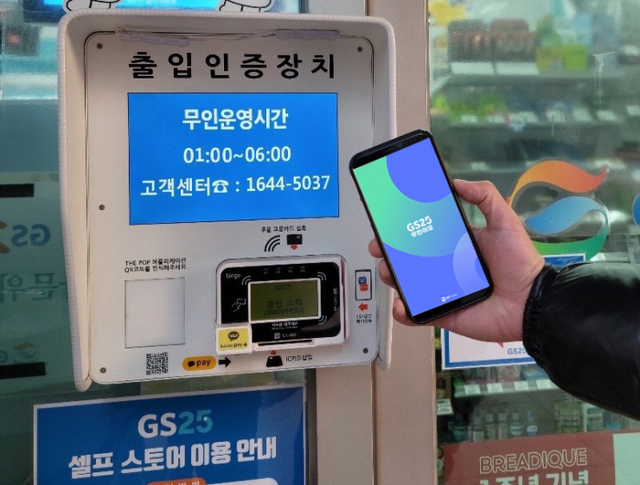 GS25 무인점포 출입인증 시스템 앞에서 점포 관리 앱 무인이오를 들고 있다. (제공: GS25) ⓒ천지일보 2022.1.10