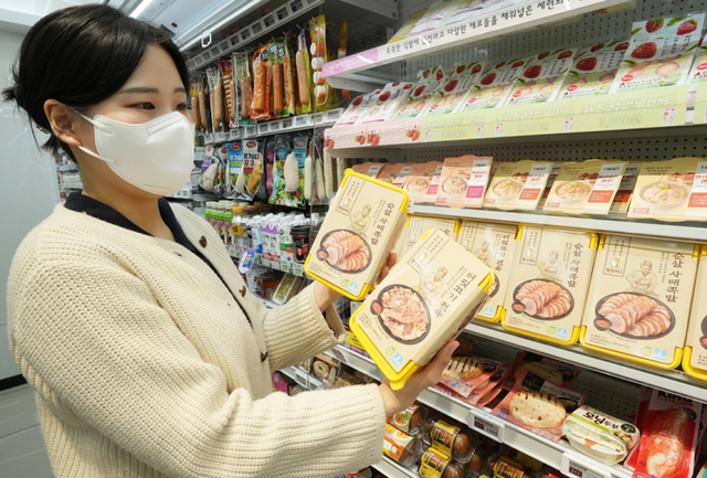 모델이 세븐일레븐에서 ‘원할머니 보쌈족발 RMR’ 2종을 선보이고 있다. (제공: 세븐일레븐)