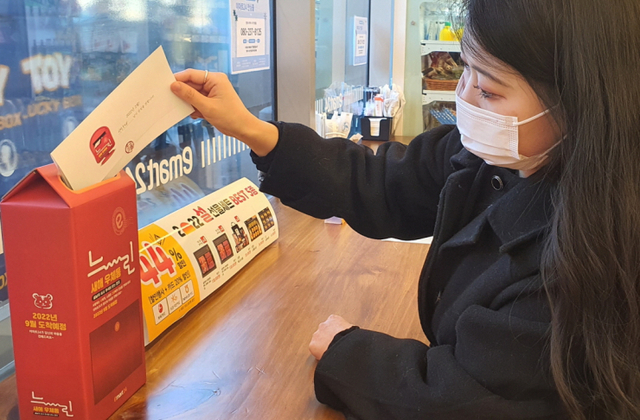 고객이 느린 편지함에 편지를 넣고 있다. (제공: 이마트24)