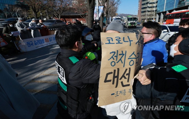 13일 서울 종로구 조계사 앞에서 열린 ‘전국 승려대회 취소 요구 기자회견’ 중 한 승려가 다가와 회견 참석자가 들고 있던 팻말을 뺏어 찢은 뒤 회견 중단을 요구하자 경찰이 이를 제지하고 있다. (출처: 연합뉴스)