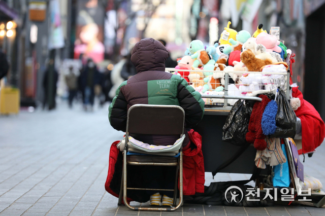 [천지일보=남승우 기자] 서울의 아침 기온이 영하 16도로 떨어지며 올 겨울 들어 가장 추운 날씨를 보인 26일 오후 서울 중구 명동거리에서 인형을 파는 한 노점상이 두꺼운 외투를 무릎에 덮어 추위를 견디고 있다. ⓒ천지일보 2021.12.26