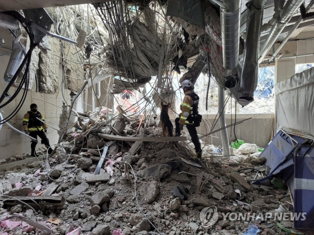 (서울=연합뉴스) 지난 13일 광주 서구 화정동 신축아파트 붕괴사고 현장에서 구조대원과 구조견이 수색작업을 벌이고 있다. 2022.1.14