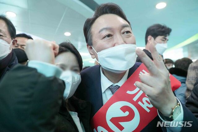 윤석열 국민의힘 대선 후보가 14일 부산 서면을 찾아 시민들과 인사를 나누고 기념촬영을 하고 있다. 2022.01.14. (출처: 뉴시스)