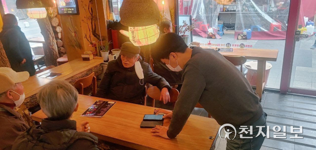 17일 서울 종로구 탑골공원 인근 한 전통찻집에서 사업주가 어르신들에게 방역패스 애플리케이션을 설치해주고 있다. ⓒ천지일보 2022.1.17