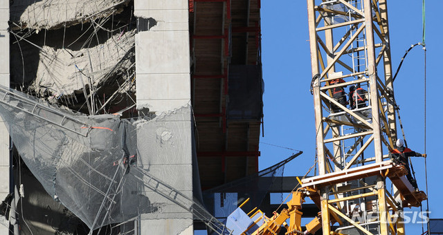 [광주=뉴시스] 광주 서구 화정동 현대산업개발 신축 아파트 붕괴 사고 8일째인 18일 오후 관계자들이 붕괴 구역 파손 크레인에서 와이어 작업을 하고 있다. 2022.01.18.