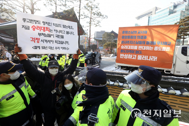 [천지일보=남승우 기자] 촛불시민연대 등 시민사회단체 회원이 20일 오후 서울 종로구 조계사 앞에서 전국승려대회 등 집단행동을 통한 정치개입 중단을 촉구하는 피켓을 들고 있다. 그 뒤로 승려대회를 반대하는 종도를 규탄하는 문구가 적힌 현수막이 보이고 있다. ⓒ천지일보 2022.1.20