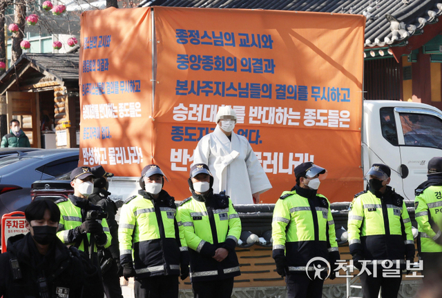 [천지일보=남승우 기자] 스님들이 20일 오후 서울 종로구 조계사 앞에서 전국승려대회 반대 종도 규탄 현수막을 내건 가운데 촛불시민연대 등 시민사회단체 주최로 열린 ‘조계종 대선개입·정치개입 규탄 결의대회’를 바라보고 있다. ⓒ천지일보 2022.1.20
