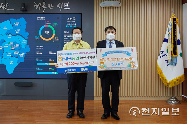 진문종 NH농협은행 아산시지부장(오른쪽)이 설명절을 앞두고 21일 아산시 관내 취약계층을 위해 떡국떡 200㎏과 농산물꾸러미 50상자를 오세현 아산시장에게 전달하고 있다. (제공: 아산시) ⓒ천지일보 2022.1.22