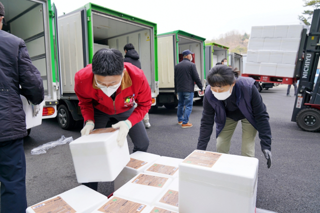 푸드뱅크 직원과 제너시스BBQ 본사 직원이 기부할 제품을 함께 상차하고 있다. (제공: BBQ)