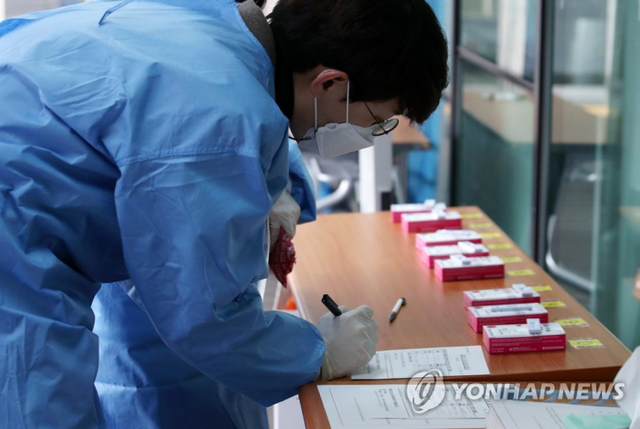 신속항원검사 키트 확인하는 의료진 (출처: 연합뉴스)