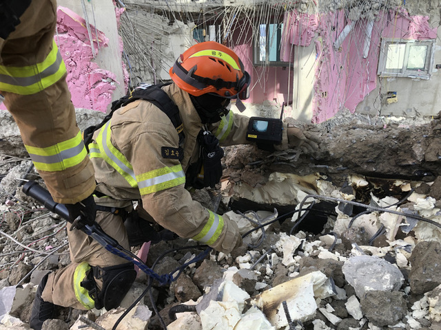 [서울=뉴시스] 30일 광주 신축공사 아파트 붕괴사고 현장에서 소방대원들이 내시경 카메라 등을 이용해 현장을 탐색하고 있다. (사진=소방청 제공) 2022.01.30.