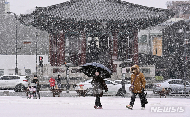 [수원=뉴시스] 수도권지역에 대설주위보가 내려진 19일 오후 경기도 수원시 팔달구 화성행궁에서 시민들이 함박눈을 맞으며 걸어가고 있다.