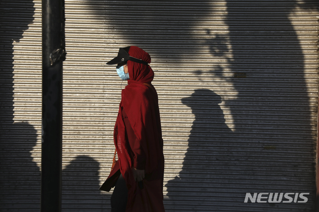 20일(현지시간) 이란 테헤란 남부에서 마스크를 낀 여성이 걷고 있다. (출처: 뉴시스)