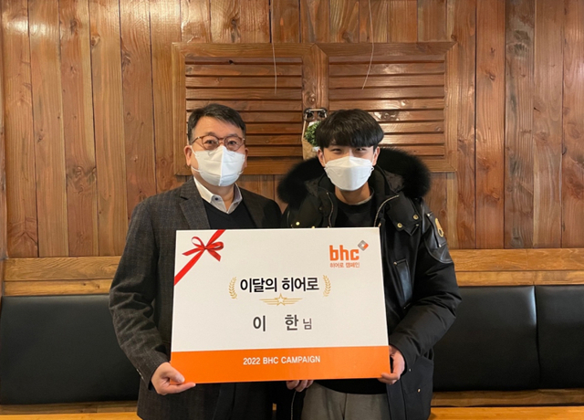 문상만 bhc치킨 가맹사업본부 본부장(왼쪽)이 지난 3일 ‘bhc 히어로’로 선정된 이한씨를 방문해 상장과 치킨 상품권을 전하고 기념사진을 촬영하고 있다. (제공: bhc치킨)