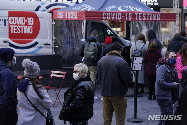 [뉴욕=AP/뉴시스] 작년 12월 13일(현지시간) 미국 뉴욕의 타임스퀘어에서 마스크를 쓴 시민들이 백신 접종을 위해 줄 서 있다.