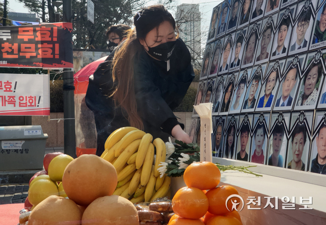[천지일보=황해연 기자] 대한불교조계종 사회노동위원회와 코로나19 백신 피해자 가족협의회(코백회)가 12일 서울 종로구 청계광장에서 개최한 ‘신종 코로나바이러스 감염증(코로나19) 백신 희생자 추모 및 진상규명과 피해자 대책마련 촉구 기도회’를 개최한 가운데 유가족들이 국화꽃을 헌화하고 있다. ⓒ천지일보 2022.2.12