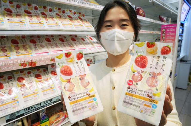 모델이 ‘첫눈에 반한 딸바초코칩 딸기샌드’를 선보이고 있다. (제공: 세븐일레븐)