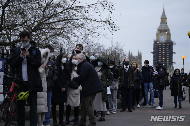 [런던(영국)=AP/뉴시스] 지난해 12월14일(현지시간) 영국 런던 세인트 토마스 병원 앞에서 시민들이 코로나19 부스터샷 접종을 기다리는 모습. 2022.01.05.