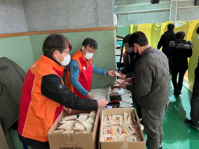SK텔레콤 구성원들이 지난 5일 경북 울진 국민체육센터에 설치된 대피소에서 주민들에게 핫팩 등 생필품을 지원하고 있다. (제공: SK)