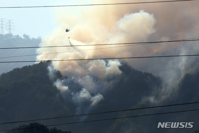 [강릉=뉴시스] 6일 오후 육군 헬기 조종사가 강원 강릉시 옥계면 남양2리 야산에서 발생한 산불 현장으로 안전하게 비행하며 물을 투하하고 있다.