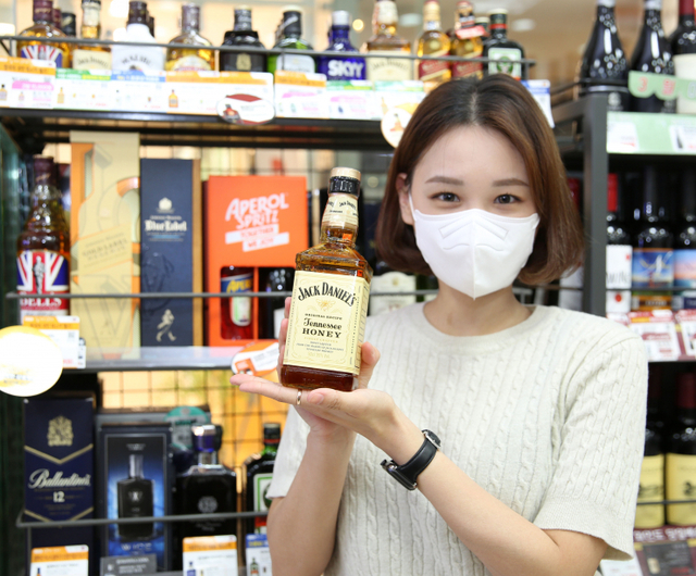 모델이 위스키 상품을 들고 포즈를 취하고 있다. (제공: GS리테일)