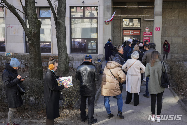 14일(현지시간) 폴란드 바르샤바의 여권사무소 앞에서 주민들이 줄을 서고 있다. 전날 폴란드로부터 약 24㎞ 떨어진 우크라이나 서부에서 러시아의 미사일 공격이 발생해 최소 35명이 숨지면서 폴란드 주민들 사이에 공포는 커지고 있다. (출처: 뉴시스)