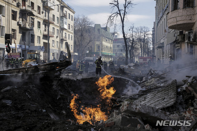 [하르키우=AP/뉴시스] 14일(현지시간) 우크라이나 하르키우에서 소방관들이 러시아의 로켓 공격으로 파괴된 아파트의 불을 끄고 있다.