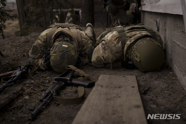 [이르핀=AP/뉴시스] 13일(현지시간) 우크라이나 키이우 외곽 이르핀에서 우르라이나 군인들이 러시아의 포격으로부터 엄폐하고 있다. 2022.03.14.