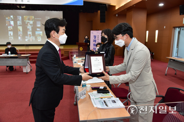조규일 진주시장(왼쪽)이 24일 시청 2층 시민홀에서 열린 ‘시민소통위원회 분과활동 성과발표회’에서 한 유공자에게 표창패를 전달하고 있다. (제공: 진주시) ⓒ천지일보 2022.3.24