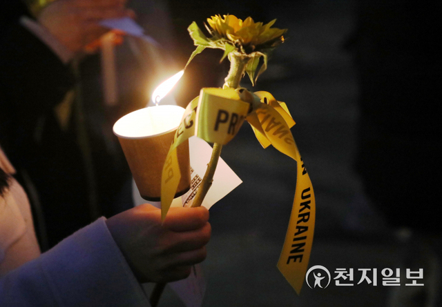 [천지일보=남승우 기자] 러시아가 우크라이나를 침공한 지 한 달째를 맞은 24일 오후 서울 중구 주한러시아대사관 인근에서 국제엠네스티 한국지부 주최로 열린 ‘우크라이나 평화기원 행사’에서 참가자들이 촛불과 우크라이나의 국화인 해바라기를 손에 들고 있다. ⓒ천지일보 2022.3.24