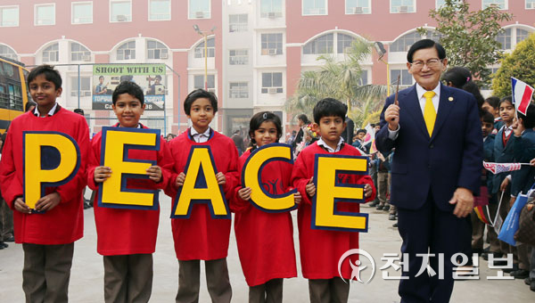 2015년 12월 20일 라마갸학교에서 진행된 HWPL 평화학교 선정 기념식에서 학생들이 ‘PEACE’가 적힌 손피켓을 들고 이만희 HWPL 대표(맨 오른쪽)를 맞이한 후 기념 사진을 촬영하고 있다. (제공: HWPL) ⓒ천지일보 2022.3.30