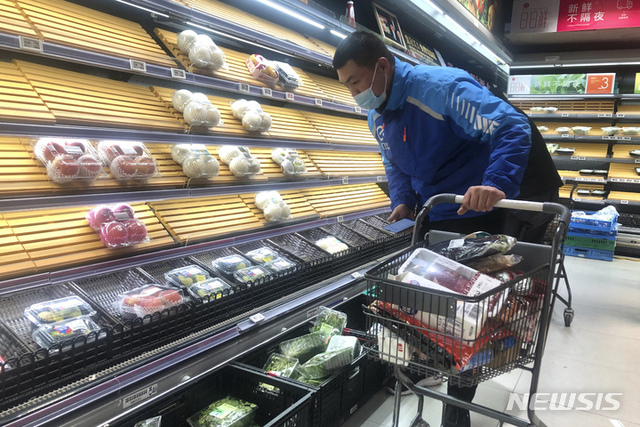 [상하이=AP/뉴시스] 30일 중국 상하이의 슈퍼마켓에서 한 배달원이 부분적으로 비어 있는 진열대의 물건을 고르고 있다. 코로나19로 인한 상하이 봉쇄로 경제 피해가 우려되면서 현지 당국은 상하이 내 상점주들에 대한 감세를 약속했으며 산업과 무역 활동의 혼란을 피하기 위해 항구의 기능을 유지하겠다고 밝혔다. 2022.03.30.