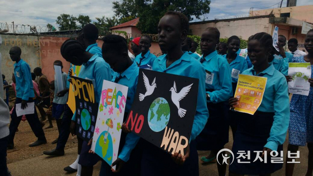 2018년 5월 25일 남수단에서 열린 세계평화선언문 5주년 기념식에 참석한 청소년 회원들이 ‘NO WAR’가 적힌 피켓을 들고 행진하고 있다ⓒ천지일보(제공:IPYG)