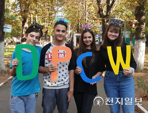 2019년 10월 14~24일 루마니아 트르구 무레슈 시 성곽에서 열린 ‘HWPL 한국 문화전시회’에서 청년들이 ‘DPCW’ 문구를 만들어 보이고 있다. (제공: HWPL) ⓒ천지일보 2022.4.15
