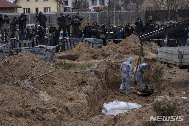 [부차=AP/뉴시스] 13일(현지시간) 우크라이나 키이우 외곽 부차의 집단 매장지에서 작업자들이 민간인 사망자들의 신원 확인을 위해 시신을 발굴하고 있다. 2022.04.14.