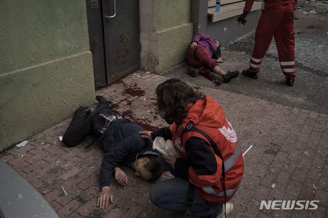 [하르키우=AP/뉴시스] 17일(현지시간) 우크라이나 하르키우에서 구조대가 러시아군의 포격으로 부상한 주민들을 돌보고 있다.