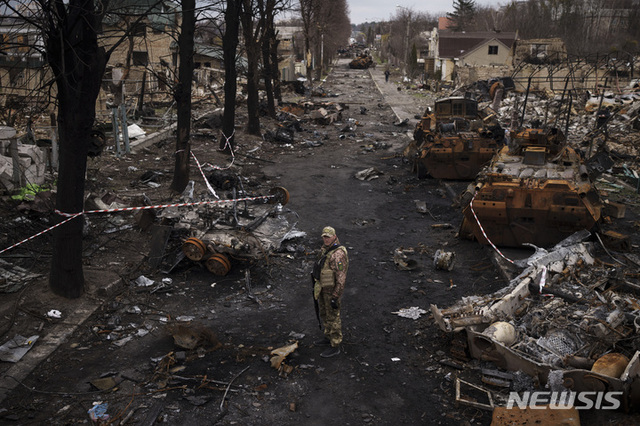 [부차=AP/뉴시스] 지난 6일(현지시간) 우크라이나 키이우 외곽 부차에서 우크라이나 군인이 파괴된 러시아군 전차들을 살피고 있다.