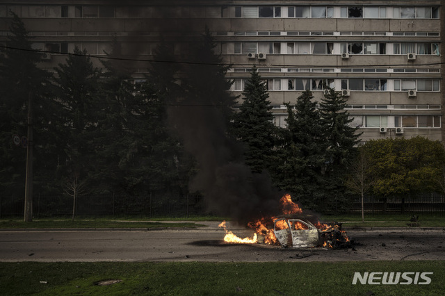 [하르키우=AP/뉴시스] 21일(현지시간) 우크라이나 하르키우에서 러시아군의 포격으로 두 사람이 탑승한 자동차가 불타고 있다.
