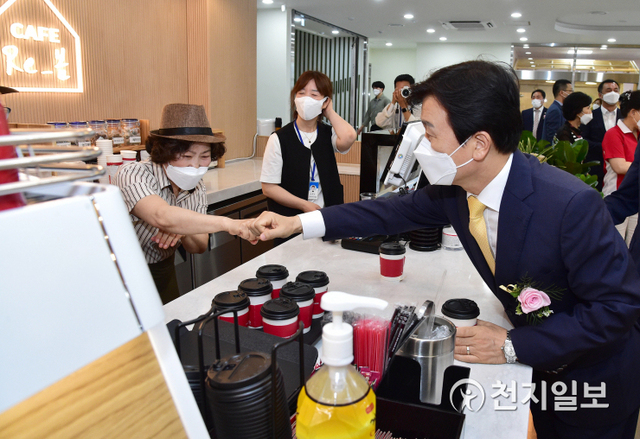 16일 오후 진주시립서부도서관 개관식에 맞춰 함께 개점한 실버카페 ‘카페Re_봄 진주서부도서관점’에서 조규일 시장이 근로자와 주먹인사를 하고 있다. (제공: 진주시) ⓒ천지일보 2021.6.16
